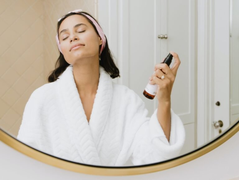 woman in white bathrobe holding smartphone